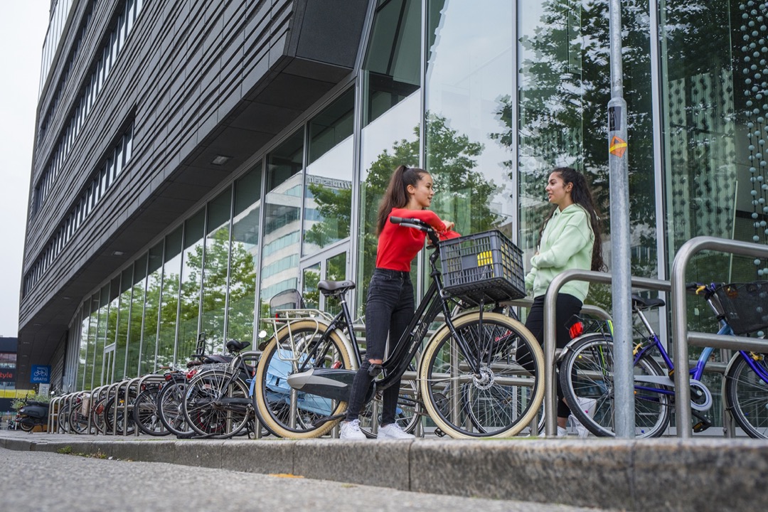 Jongeren met fietsen naast de Nieuwe Bibliotheek