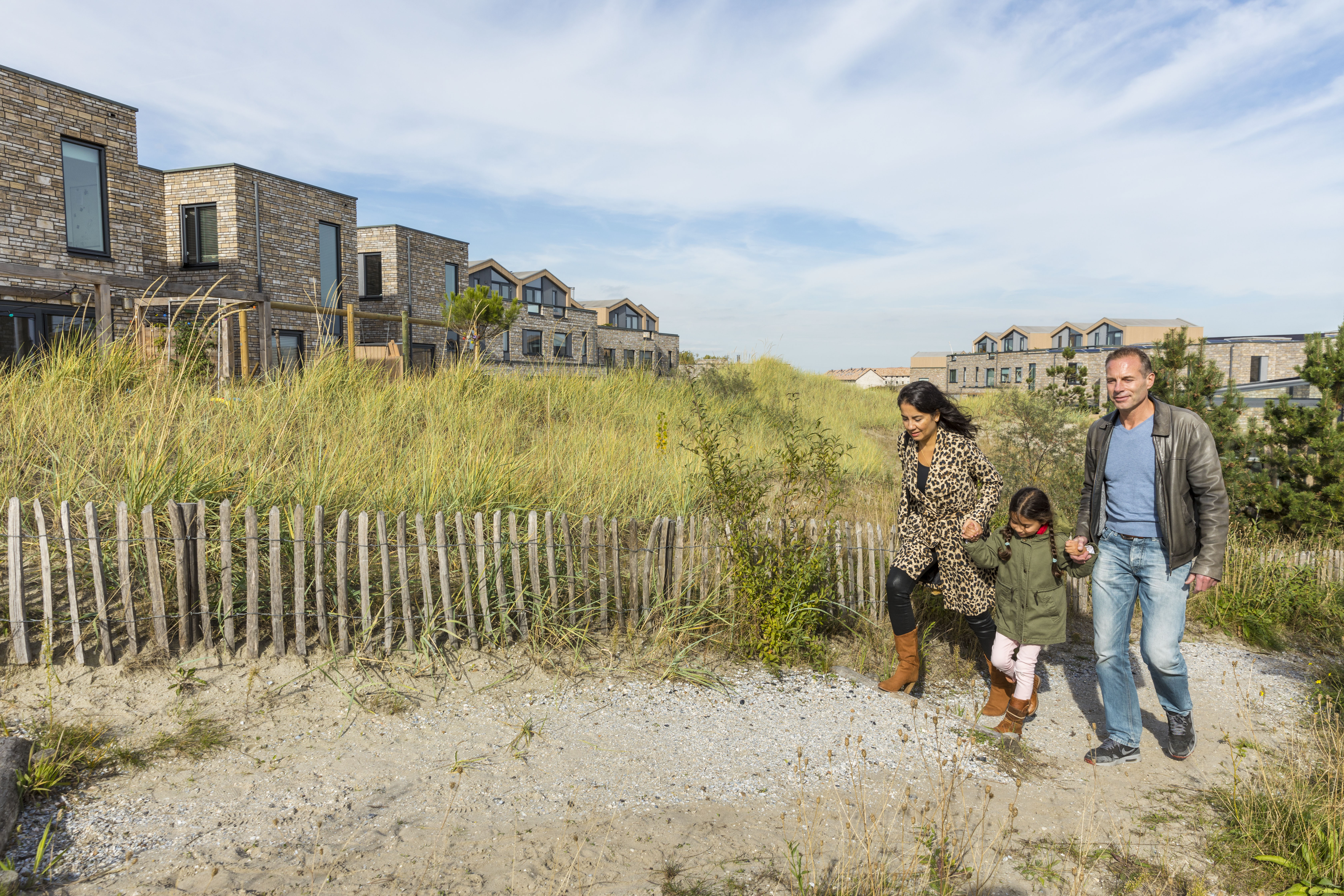 Een familie wandelend door de nieuwe woonwijk Almere Duin